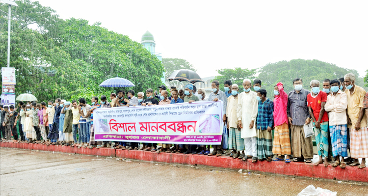 বিশ্বনাথে অপরিকল্পিত’ ড্রেন নির্মাণের প্রতিবাদে বৃষ্টিতে ভিজে মানববন্ধন